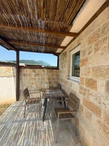 a patio with a table and chairs on a brick wall at Mila in Danilovgrad