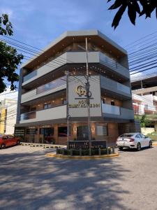 a building with a car parked in front of it at Hotel Guest House Inn in San Pedro Sula