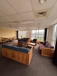 a large room with couches and tables and windows at Hotel Laurier - King Street Residence in Waterloo