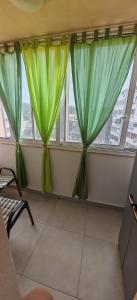 a room with green curtains in front of a window at Apartman Nenad in Pula