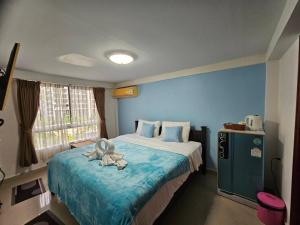 a bedroom with a bed with a towel on it at Hello Jomtien in Jomtien Beach