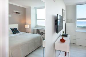 a bedroom with a bed and a desk and a tv at MVR Suite Wellness Like You have Never Felt Before in Miami