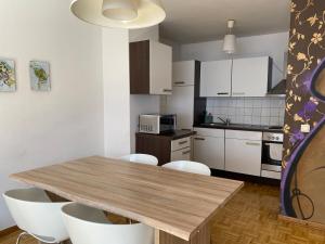a kitchen with a wooden table and white cabinets at Apartment 8 at Cologne Cathedral in Cologne