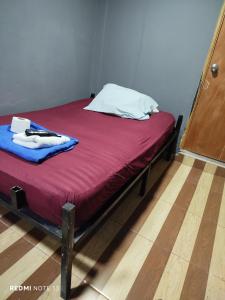 メデジンにあるDulce Hogar Aparta Hotelの赤い毛布と白い枕が置かれたベッド