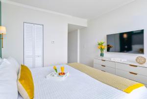 a white bedroom with a bed with a tv on it at MVR Suite Where Your Miami Memories Begin in Miami