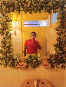 a man taking a picture of himself in a bathroom mirror at Hotel Palma Paraíso in Melgar