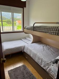 two bunk beds in a room with a window at A casa do Cabezo in Mougás