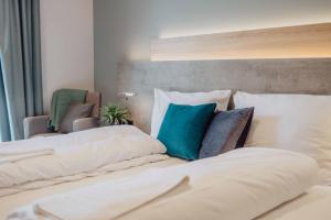 a bedroom with two white beds with blue pillows at Pascals Ruhestube in Mörsdorf