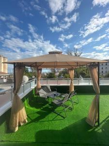 un patio con 2 sillas y una sombrilla grande en First Line Apartment, en Balchik