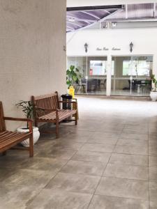un hall avec deux bancs et une salle avec des tables dans l'établissement Ótima Kitnet pé na areia na praia de Pitangueiras c/ vista para o mar., à Guarujá 28 autres photos