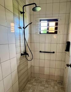 a shower with a shower head in a bathroom at ELY'S Appartment #1 in Paramaribo +8 photos