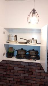 una cocina con 2 ollas y sartenes en una estufa en kitnet aconchegante Miguel Pereira, en Miguel Pereira