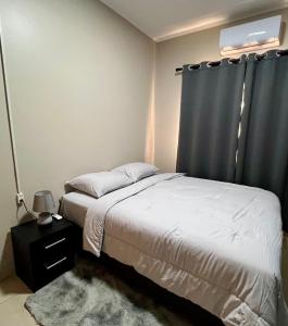 a bedroom with a bed and a black curtain at ELY'S Appartment #1 in Paramaribo