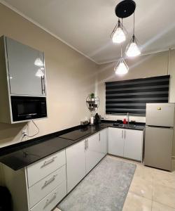 a kitchen with white cabinets and a black counter top at ELY'S Appartment #1 in Paramaribo