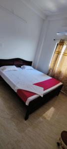 ブッダガヤにあるGlamour Palaceの窓のある部屋にある大きなベッド