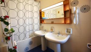 a bathroom with two sinks and a mirror at Phalanthos B&B in Leporano