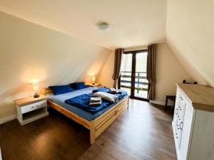 a bedroom with a large bed with blue pillows at Jak Tu Sielsko in Osiek