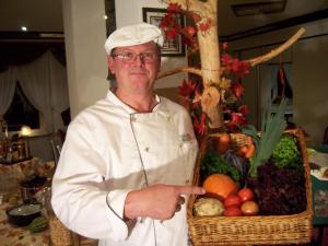 un chef sosteniendo una cesta de frutas y hortalizas en Hotel Drei Rosen en Worbis