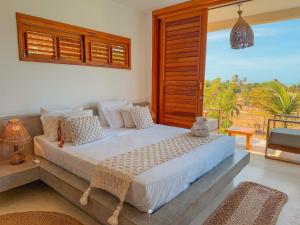 a bedroom with a bed and a large window at La Villa Dune, um luxo com vista espetacular por mar e coqueiral ! Uma experiência unica ! in Icaraí