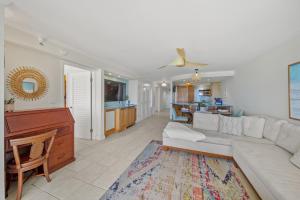 a living room with a white couch and a kitchen at Aston Waikiki Beach Tower 602 in Honolulu