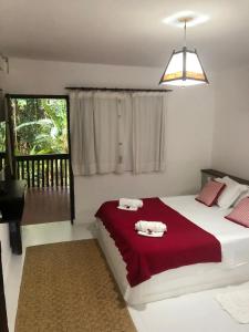 een slaapkamer met een groot bed met handdoeken erop bij Sítio de Praia in Arraial d'Ajuda +51 foto's