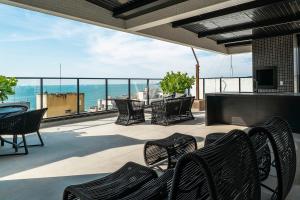a patio with chairs and a table and a view of the ocean at Apart Villa Francione in Bombas