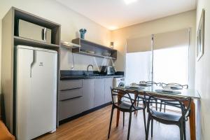 a kitchen with a table with chairs and a refrigerator at Apart Villa Francione in Bombas