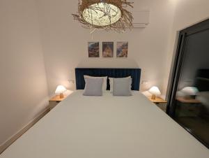 a bedroom with a large white bed with two lamps at Breathtaking Oceanfront Living, Sunset Facing 3-Bedroom Flat in Acqua Residences in Funchal +43 photos