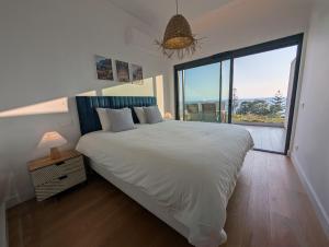 a bedroom with a large bed and a large window at Breathtaking Oceanfront Living, Sunset Facing 3-Bedroom Flat in Acqua Residences in Funchal