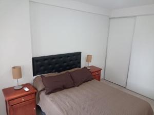 a bedroom with a large bed and two night stands at Casita de Tucuman in San Miguel de Tucumán