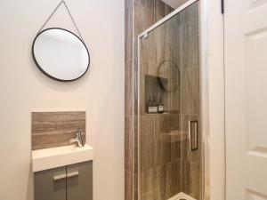 Un baño con ducha con espejo y lavabo. en The Cow Shed, en Truro 22 fotos más
