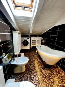 a bathroom with a tub and a sink and a washing machine at Vila Cochet in Braşov
