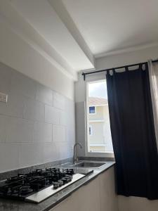 a kitchen with a stove and a sink and a window at Bavaro Punta Cana Beach pool ducassi sol caribe Los corales in Punta Cana