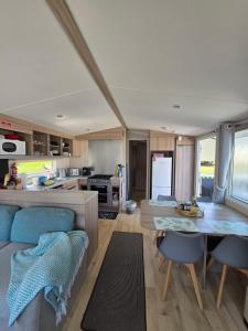 a kitchen and living room with a table and chairs at Barbara's Caravan Craig Tara in Ayr