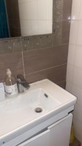 a bathroom with a white sink and a mirror at Πόλη της Κέρκυρας διαμέρισμα in Corfu