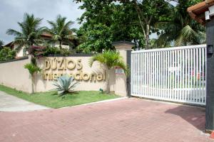 una cerca blanca con un cartel que dice Ducos International en Buzios Beach Internacional Residence Service, en Búzios