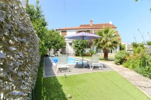 ein Haus mit einem Pool, 2 Stühlen und einem Sonnenschirm in der Unterkunft Apartment Milena in Srima + 15 Fotos