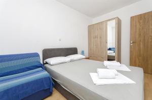 ein Schlafzimmer mit einem Bett mit blau-weißer Bettwäsche in der Unterkunft Apartment Milena in Srima