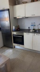 a kitchen with a stove and a refrigerator in it at Πόλη της Κέρκυρας διαμέρισμα in Corfu