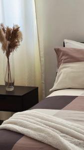 a vase of flowers on a table next to a bed at Bavaro Punta Cana Beach pool ducassi sol caribe Los corales in Punta Cana