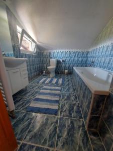 a bathroom with a sink and a tub and a toilet at Apartman Aldina in Bihać