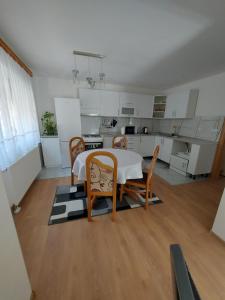 a room with a table and chairs and a kitchen at Apartman Aldina in Bihać