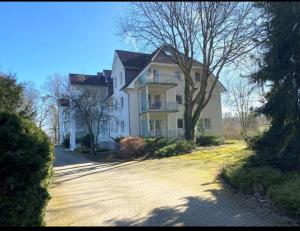 a large white house with a tree in front of it at Seeperle in Lalendorf