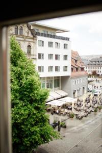 a large white building with tables and chairs in a city at Ferienwohnung Alte Münze mit Parkplatz in Zwickau