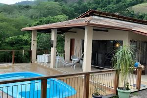 a house with a swimming pool on a deck at Sítio das Flores, 7 Km do centro de Castelo in Estancia do Castello