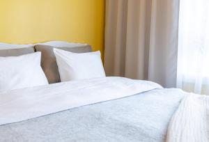 a white bed with white sheets and a window at Lovely nest in Nõmme in Tallinn