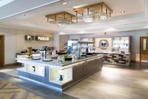 a restaurant with a counter in the middle of a room at Mercure Newcastle George Washington Hotel Golf & Spa in Newcastle upon Tyne