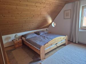ein Bett in einem Zimmer mit Holzdecke in der Unterkunft Singer-Hof in Krumpendorf am Wörthersee