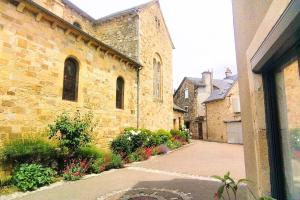 an old stone building with a courtyard with flowers at Le Cocon de Vimenet in Vimenet