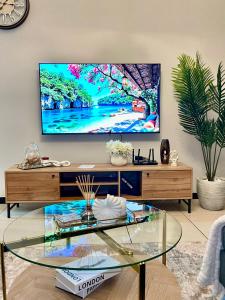 a living room with a flat screen tv on a wall at Luxury 1-Bedroom Apartment in Fourways-Sandton with FREE Gym, swimming Pool and Restaurant in Fourways